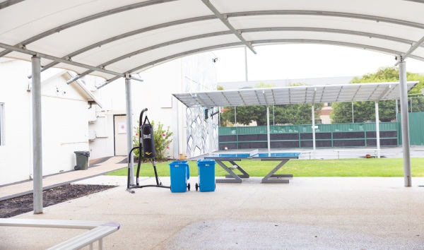 The outside area of the Youth Futures Community School in Midland with a boxing bag, ping pong table, and a basketball court