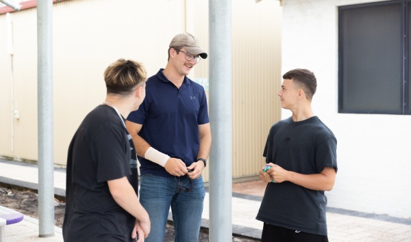 A man talking to two students from the Youth Futures Community School in Midland