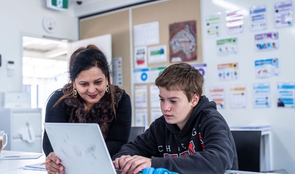 Woman helping boy with schoolwork at the Youth Futures Community School in Midland
